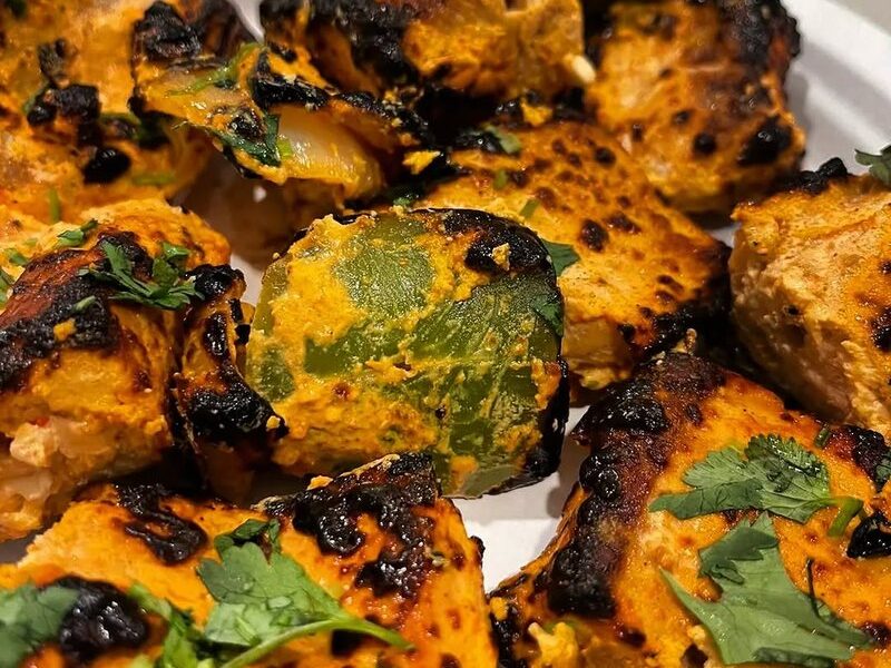 Tandoori salmon tikka with peppers and onion, charred in the clay oven